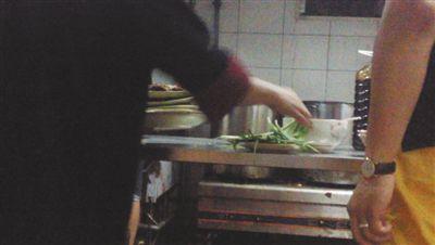 7月23日，漢麗軒烤肉超市昌平店，服務(wù)員將幾盤顧客剩菜（左手中疊在一起的是幾盤肉，其右手正整理韭菜）端回后廚，進(jìn)行整理后準(zhǔn)備再送往餐廳自助取餐區(qū)供顧客食用。